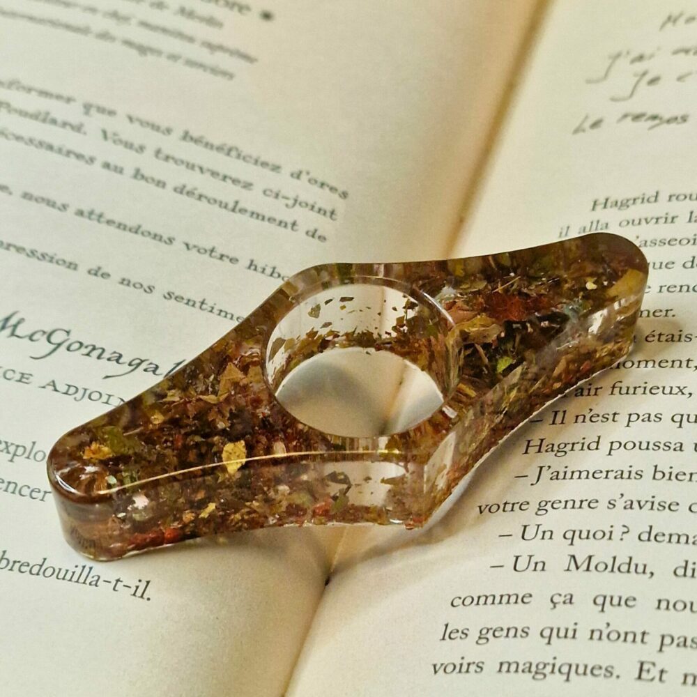 Accessoire de lecture artisanal en liège et feuilles naturelles posé sur un livre ouvert